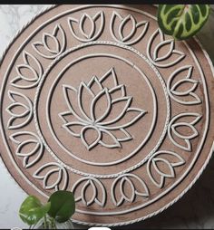 a circular design on the side of a table next to a potted green plant