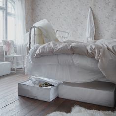 a white bed sitting on top of a wooden floor