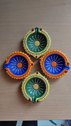 three decorative dishes sitting on top of a wooden table