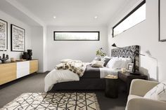 a bed sitting in a bedroom next to a dresser and chair on top of a rug