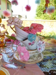 a table topped with plates and cups filled with flowers