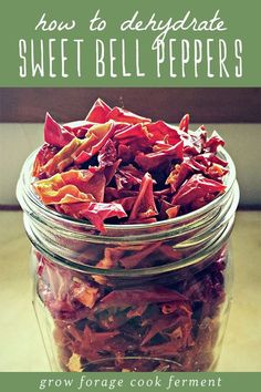 a jar filled with red peppers sitting on top of a table