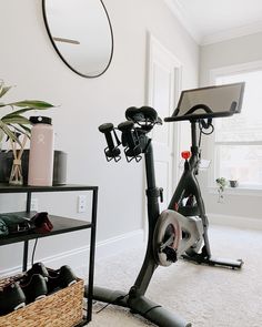 there is a bike that is in the room with shoes on it and a basket next to it