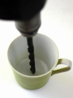 a coffee cup filled with liquid being poured into it