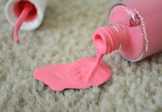 a bottle of pink paint sitting on top of a carpet