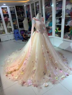 a dress with flowers on it is displayed in front of a store display case,