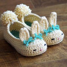 crocheted baby shoes with bunny ears and bows on the toes, sitting on a wooden floor