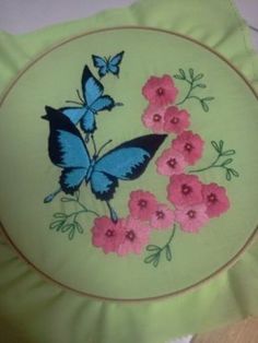 a green plate with pink flowers and blue butterflies on it, sitting on a table