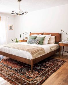 a large bed sitting on top of a wooden floor next to a window in a bedroom