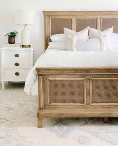 a bed with white linens and pillows in a small room next to a dresser