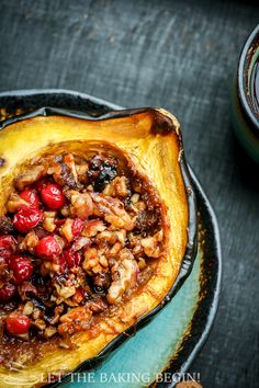 stuffed acorn squash with cranberries and pecans in it on a plate