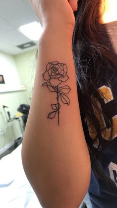 a woman with a rose tattoo on her arm