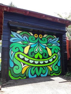 a garage door painted with green and blue designs