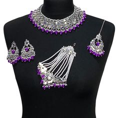 Handcrafted purple silver mirror Indian sheesha wedding / bridal jewellery set. Set includes- Earrings  Collar necklace Jhumar Tikka  Our necklace is adjustable with a dori at the back giving you a comfortable fit. It comes with simple elegant mirror earrings with pearl detail, tikka and jhumar with hooks.  The glimmer of the mirrors with elegant pearl detail make this jewelry set a truly head turning piece, a must have for every jewellery box.  Our ethnic jewellery set harmoniously blends the a Festive Bollywood Purple Jewelry, Festive Purple Bollywood Jewelry, Purple Kundan Jewelry For Diwali, Silver Jewelry Sets With Mirror Work For Festivals, Bollywood Style Silver Bridal Necklace With Mirror Work, Purple Jewelry For Wedding On Diwali, Purple Jewelry For Wedding And Diwali, Festive Purple Necklace For Wedding, Purple Kundan Bollywood Jewelry