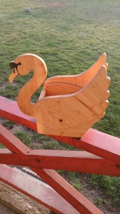 a wooden swan sitting on top of a red bench