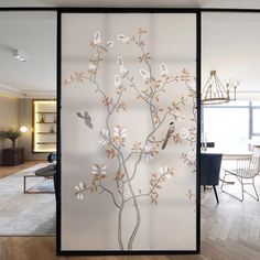 a glass wall with birds on it in a living room and dining room area,