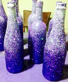 purple glitter bottles sitting on top of a table