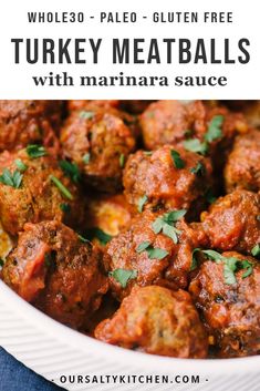 a white bowl filled with meatballs and garnished with parsley on top