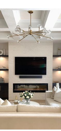 a living room filled with furniture and a flat screen tv mounted on the wall above a fireplace