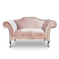 a pink velvet chair with silver trimmings and nail polishing on the legs