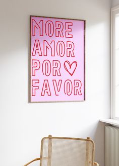 a pink poster hanging on the wall above a chair in a room with white walls