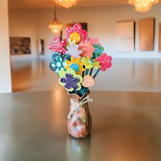 a vase filled with lots of colorful flowers on top of a table