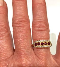 Detailed band style ring has 24 round diamonds set with an outside solid gold edge. This surrounds 5 round vibrant red rubies. Below the gemstones, is a lovely azured out U shaped under gallery. The ring is 14K high polished yellow gold. Would be a great idea for a wedding band / anniversary band. Ring is a size 6 1/2 and can be resized 24 round diamonds app. .24cts 5 round rubies app. .50cts., rubies have a vibrant red color Item # 078 DR 2312 July Birthstone Ring, Round Diamond Setting, 1980s Fashion, July Birthstone, Anniversary Bands, Multi Stone Ring, Vibrant Red, Anniversary Rings, Round Diamonds