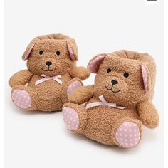 two brown teddy bears sitting next to each other on a white surface with pink polka dots