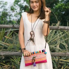 "This beautiful crossbody bag is made with an amazing piece of fabric woven by the HMONG hill tribes of Lanna Country (Northern Thailand). It decorate with multi pom pom. It features a zippered opening area, inside zippered pocket and removable strap. It's a great bag for carrying anything. We buy materials from Hmong market and we design and sew by hand. Some of the bags we modify to improve the product. The Hmong tribes live in the North of Thailand and have origins from the Tibetan area of Ch Embroidered Clutch Shoulder Bag For Travel, Bohemian Woven Clutch Shoulder Bag, Woven Pouch Shoulder Bag For Festivals, Bohemian Style Clutch Shoulder Bag For Travel, Bohemian Clutch Shoulder Bag For Travel, Bohemian Everyday Use Pouch, Festival Clutch Shoulder Bag, Bohemian Crossbody Clutch For Travel, Bohemian Crossbody Clutch For Everyday