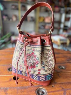 Thank you for visiting our shop!  It's very useful bag as shoulder and as crossbody bag.  This bag is spacious and holds a lot of things. Size         : 30cm x 27cm x 8cm Material  : wool / leather We select beautiful vintage kilims from all over the anatolian area and middle east area. and We do special wash for Kilim rug first, after that cut the kilim to remake unique kilim bags at our atelier  one by one. All products have been produced in a smoke-free environment.  Vintage kilim with colore Brown Bucket Bag With Detachable Handle For Daily Use, Everyday Use Hobo Bag With Detachable Strap, Everyday Bucket Hobo Bag With Detachable Strap, Crossbody Travel Bucket Bag With Dust Bag, Crossbody Bucket Bag With Dust Bag For Travel, Travel Shoulder Bag With Detachable Handle In Bucket Shape, Travel Bucket Shoulder Bag With Detachable Handle, Leather-handled Bucket Bag For Travel, Everyday Bucket Bag With Leather Handles