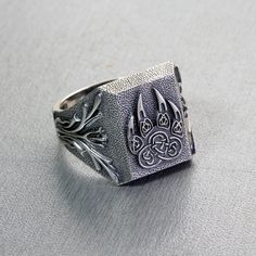 a silver ring with an intricate design on it