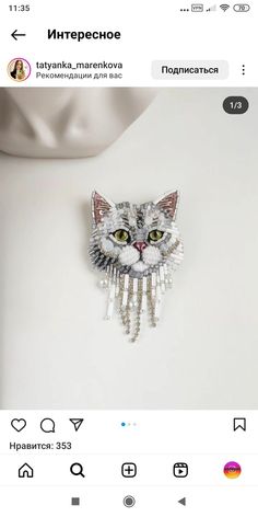 an image of a cat brooch on the back of a white dress mannequin