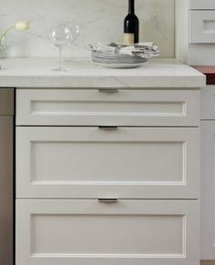 a wine bottle on top of a kitchen counter next to a dishwasher and sink