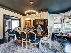 a dining room table with chairs and a chandelier hanging from it's ceiling