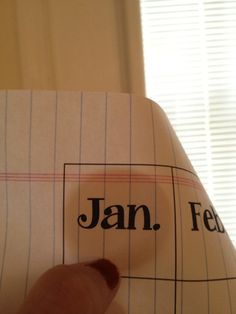 a person is pointing at a piece of paper with the word jan on it