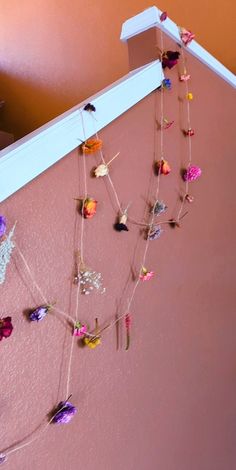 there are many small flowers hanging on the wall