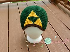 a green and yellow knitted hat sitting on top of a white mannequin head