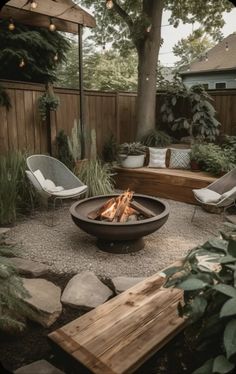 an outdoor fire pit surrounded by chairs and trees