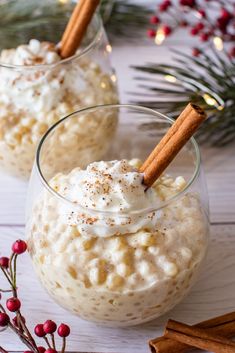 two glasses filled with oatmeal and cinnamon sticks on top of a table