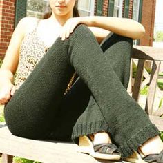 a young woman sitting on top of a wooden bench