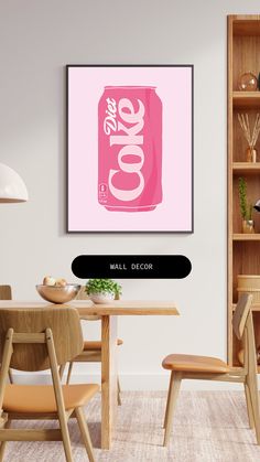 a pink coca - cola can sitting on top of a table next to a wooden chair