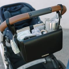 a baby stroller filled with various items in it's pocket and attached to the handlebars