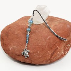 a bracelet with an elephant charm on it sitting on top of a rock