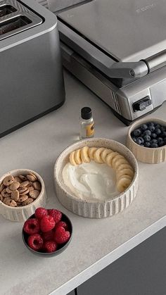 some food is sitting on a counter top next to a toaster and bowl of fruit