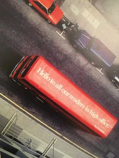 a red bus driving down a street next to tall buildings