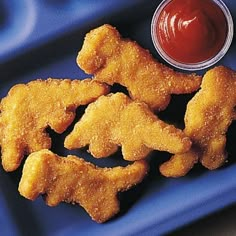 chicken nuggets and ketchup on a blue tray with a red dipping sauce