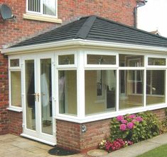 a brick house with a tiled roof and white windows