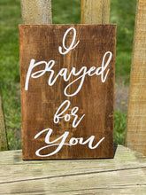 a wooden sign that says i pray for you