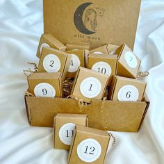 a box filled with brown boxes sitting on top of a bed next to numbers and numerals