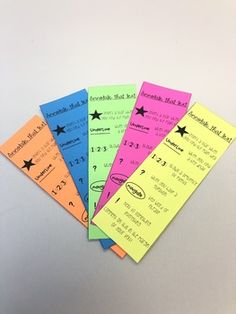 five different colored tickets sitting next to each other on top of a white countertop